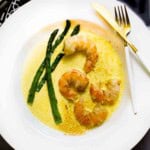 Seafood saffron cream sauce served with shrimp and asparagus.