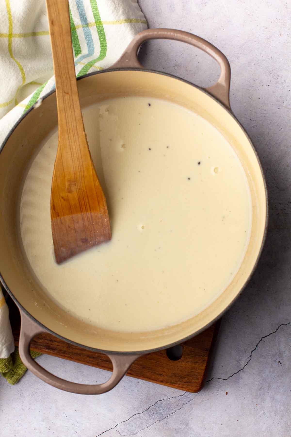 Adding milk to make a roux for mac and cheese.