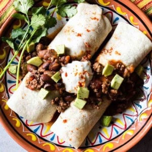 Chili burrito with rice and cheese topped with sour cream.