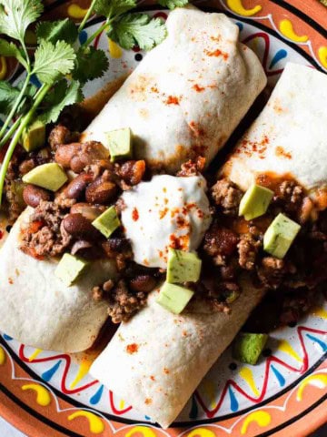 Chili burrito with rice and cheese topped with sour cream.