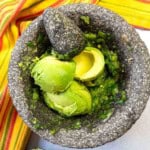Ingredients in a molcajete to make molcajete guacamole.