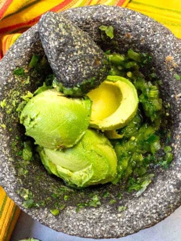 Ingredients in a molcajete to make molcajete guacamole.