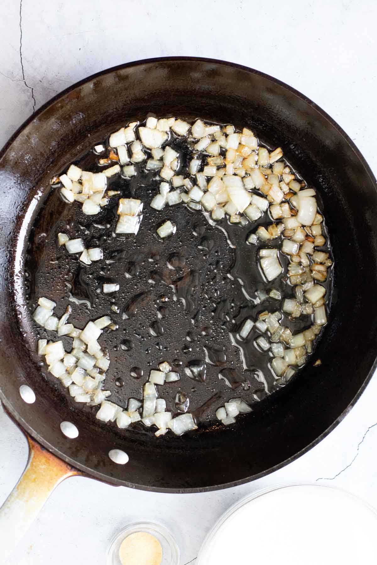Sauteeing chopped onion in a fry pan.