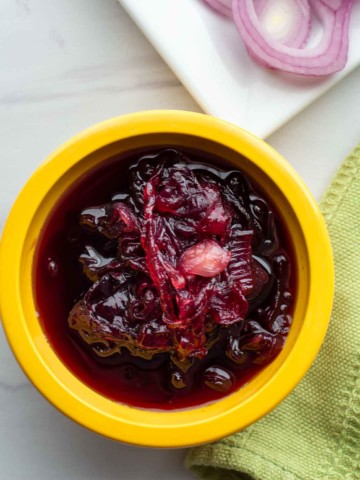 Red onion chutney in a yellow bowl.