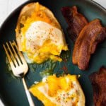 Breakfast baked potatoes twice baked with eggs, served with a side of bacon.