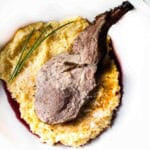 A roast rack of pork rib served over a bed of polenta.