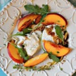 A salad with grilled peaches, arugula and goat cheese.