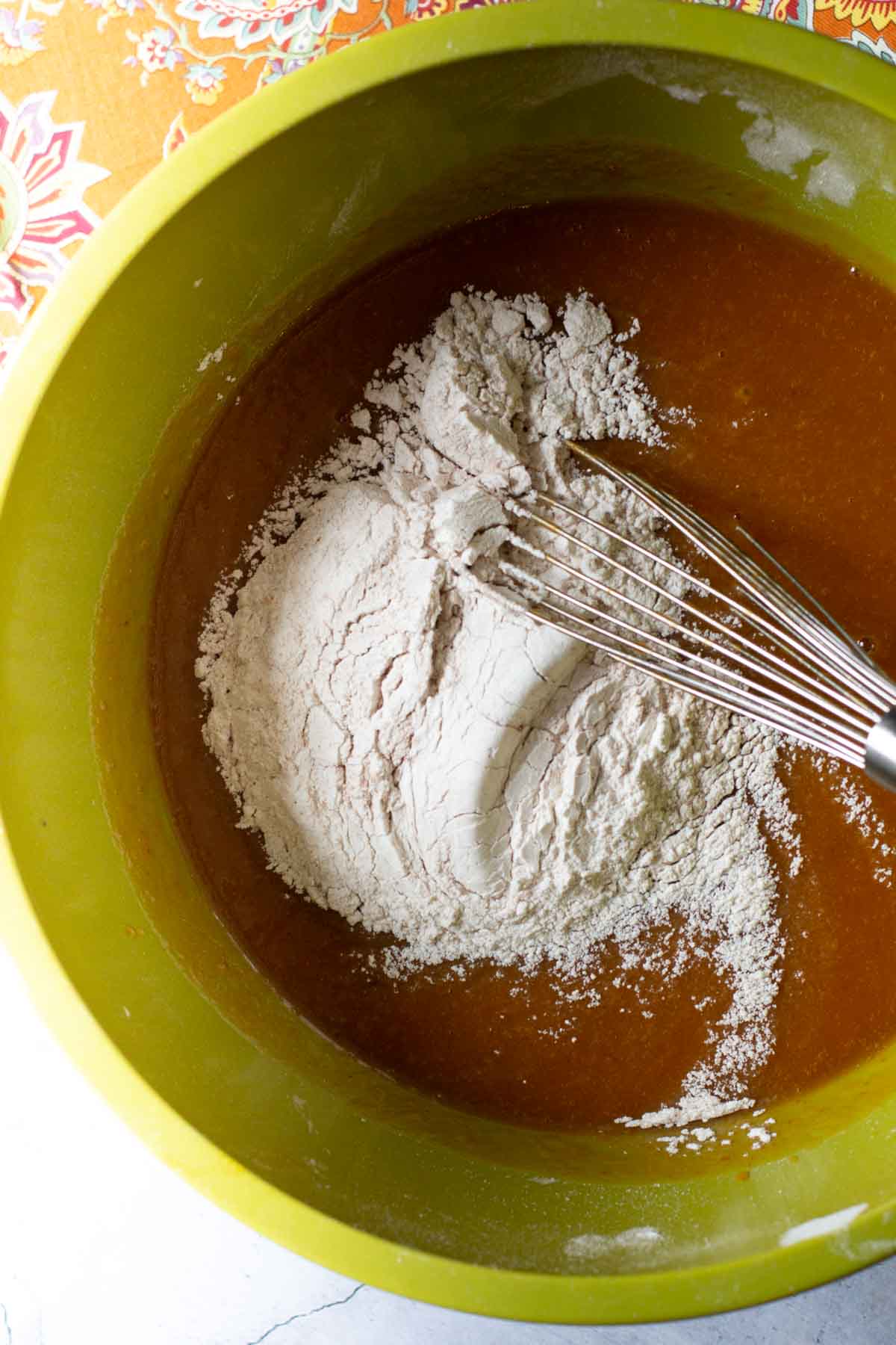 Mixing dry and wet ingredients together to make pumpkin bread.