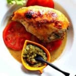 Achiote chicken served over tomatoes and with green chile sauce.