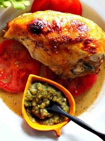 Achiote chicken served over tomatoes and with green chile sauce.