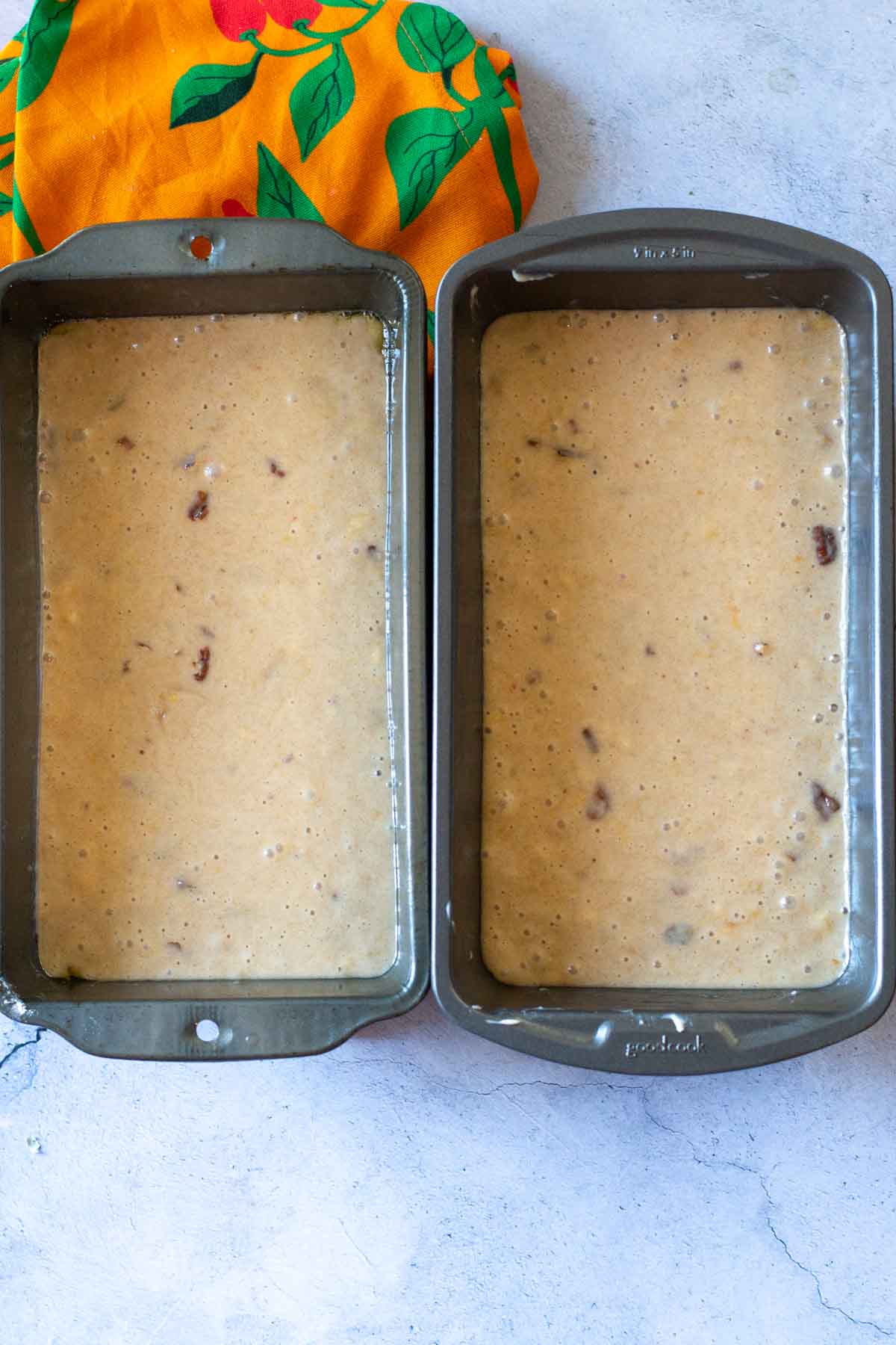 Batter in loaf pans to make peach bread.