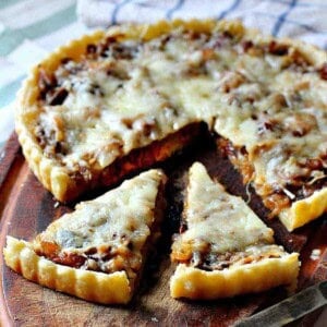 Caramelized Onion Tart on a wooden cutting board.