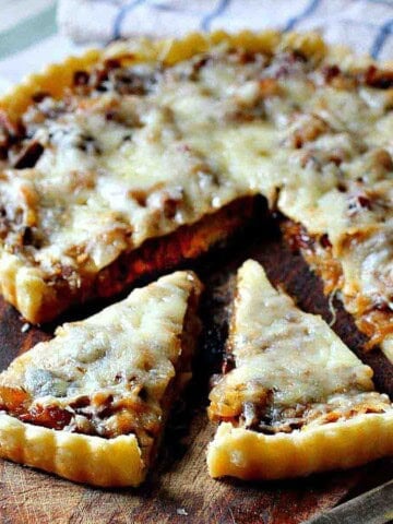 Caramelized Onion Tart on a wooden cutting board.