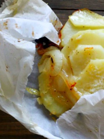 Sliced potatoes cooked in parchment paper with emmental cheese.