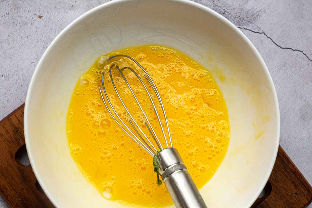 Whisking eggs to make a Western Omelette.