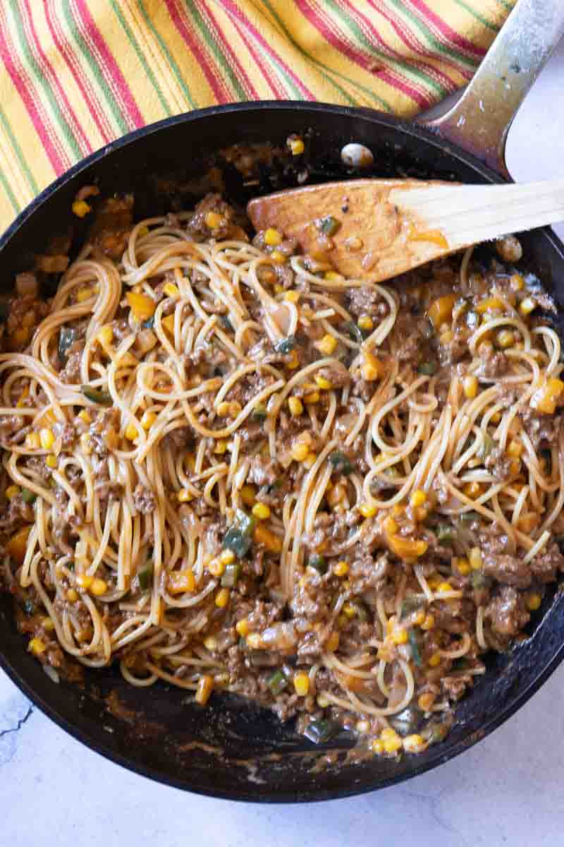Finishing cowboy spaghetti in a large fry pan.