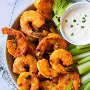 Crispy fried buffalo shrimp appetizer recipe served with celery and blue cheese dressing.