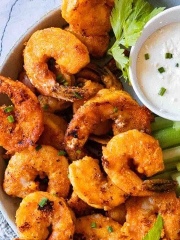 Crispy fried buffalo shrimp appetizer recipe served with celery and blue cheese dressing.