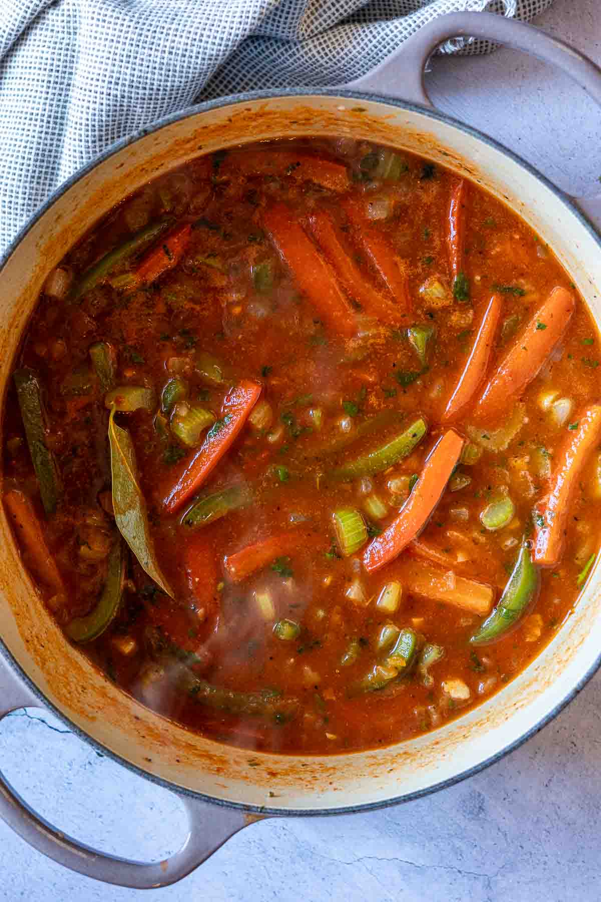 Add tomato sauce to vegetables to make shrimp stew.