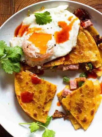 Ham and cheese quesadilla made with corn tortillas and topped with a fried egg.