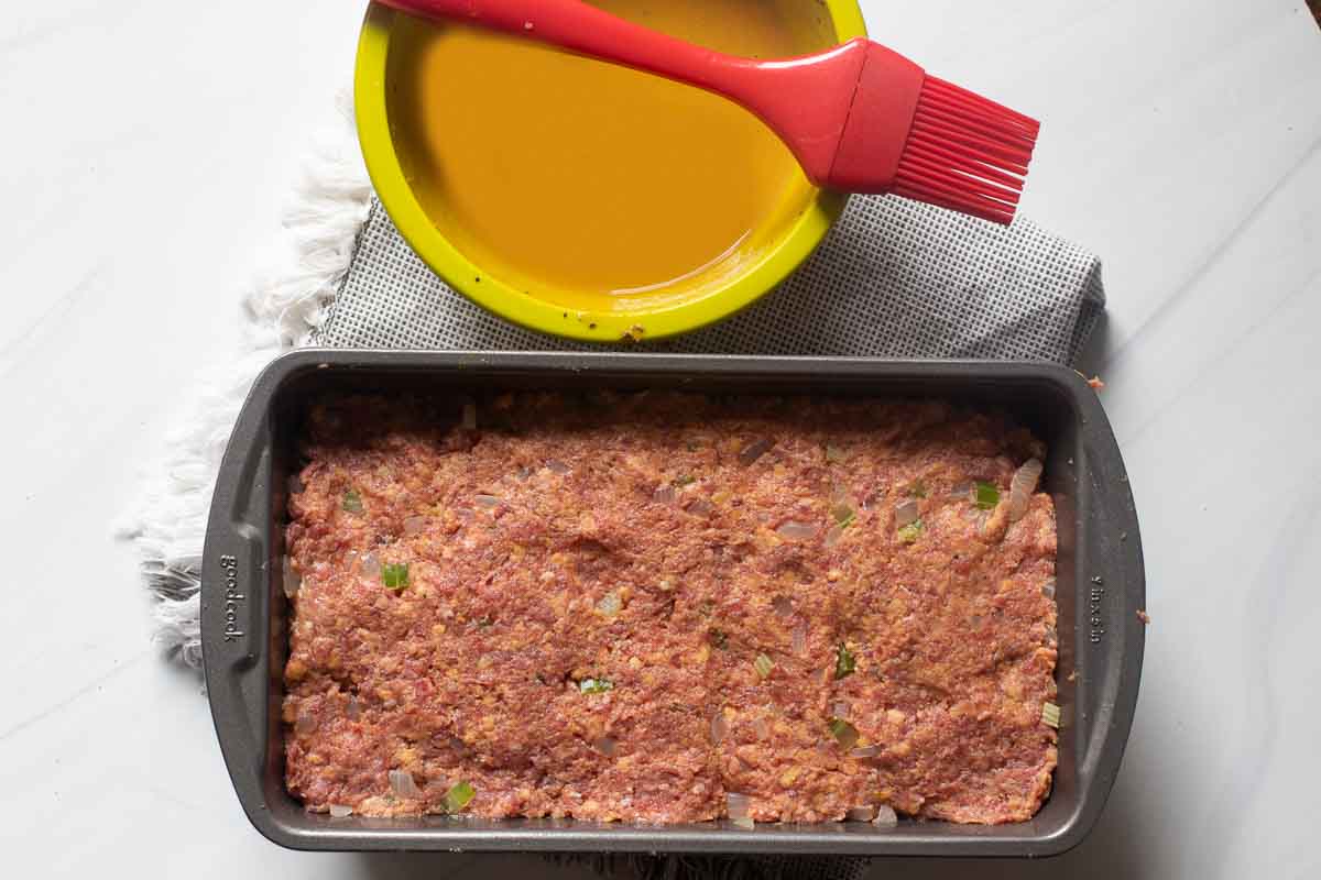 Meatloaf mixture formed into a loaf pan ready to bake.