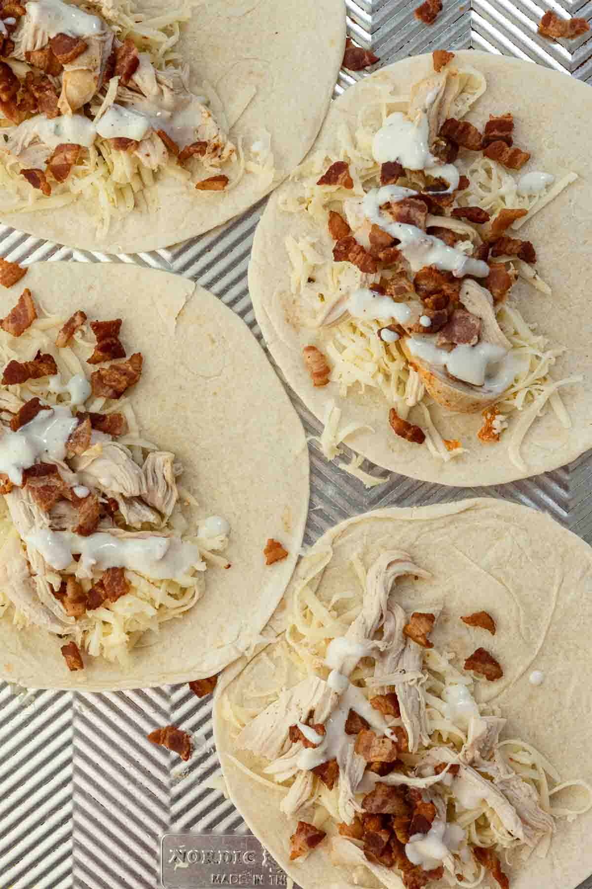 Adding chicken and bacon to make chicken bacon ranch quesadillas.