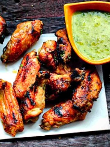 Horseradish Honey Butter chicken wings served with parsley sauce.