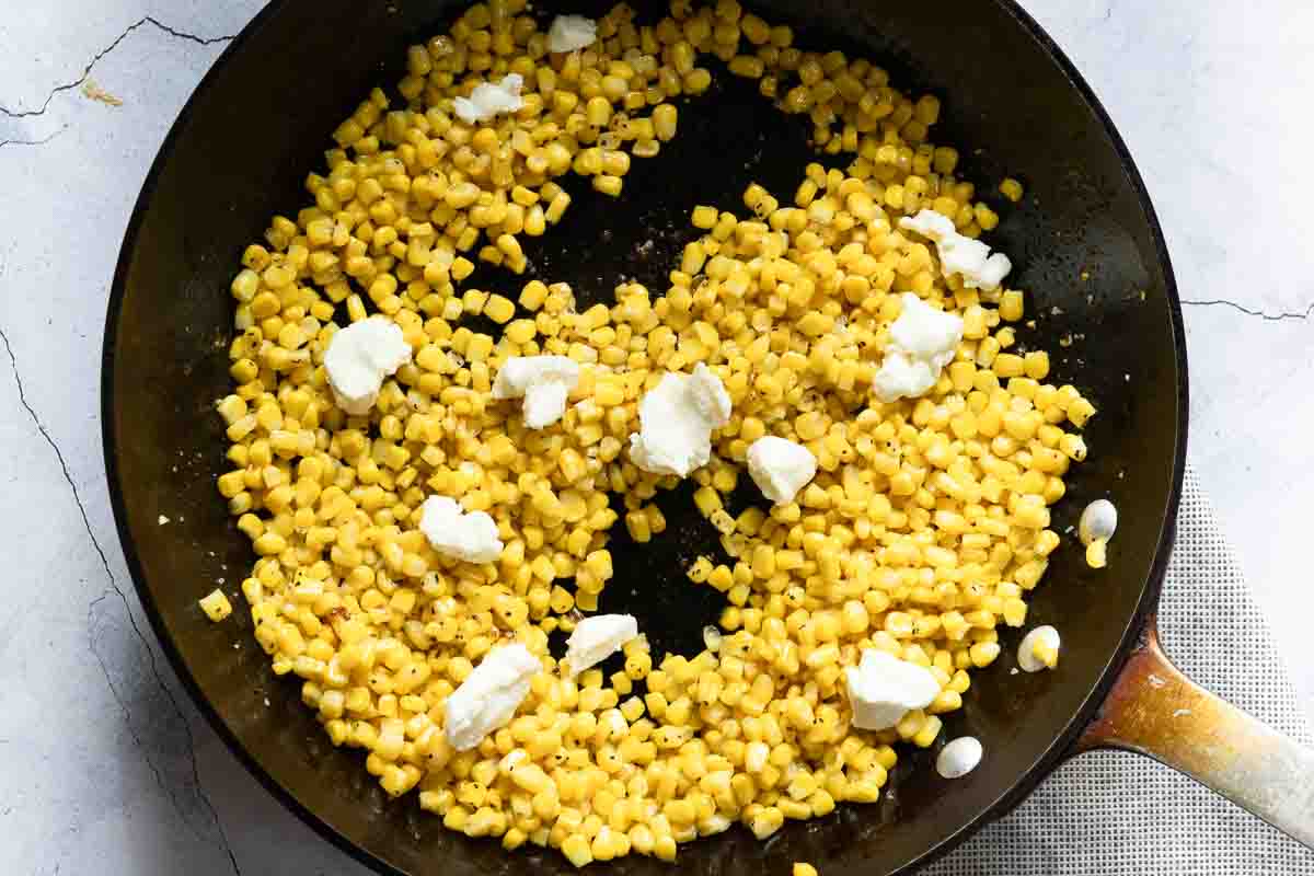 Adding cream cheese to honey butter skillet corn.