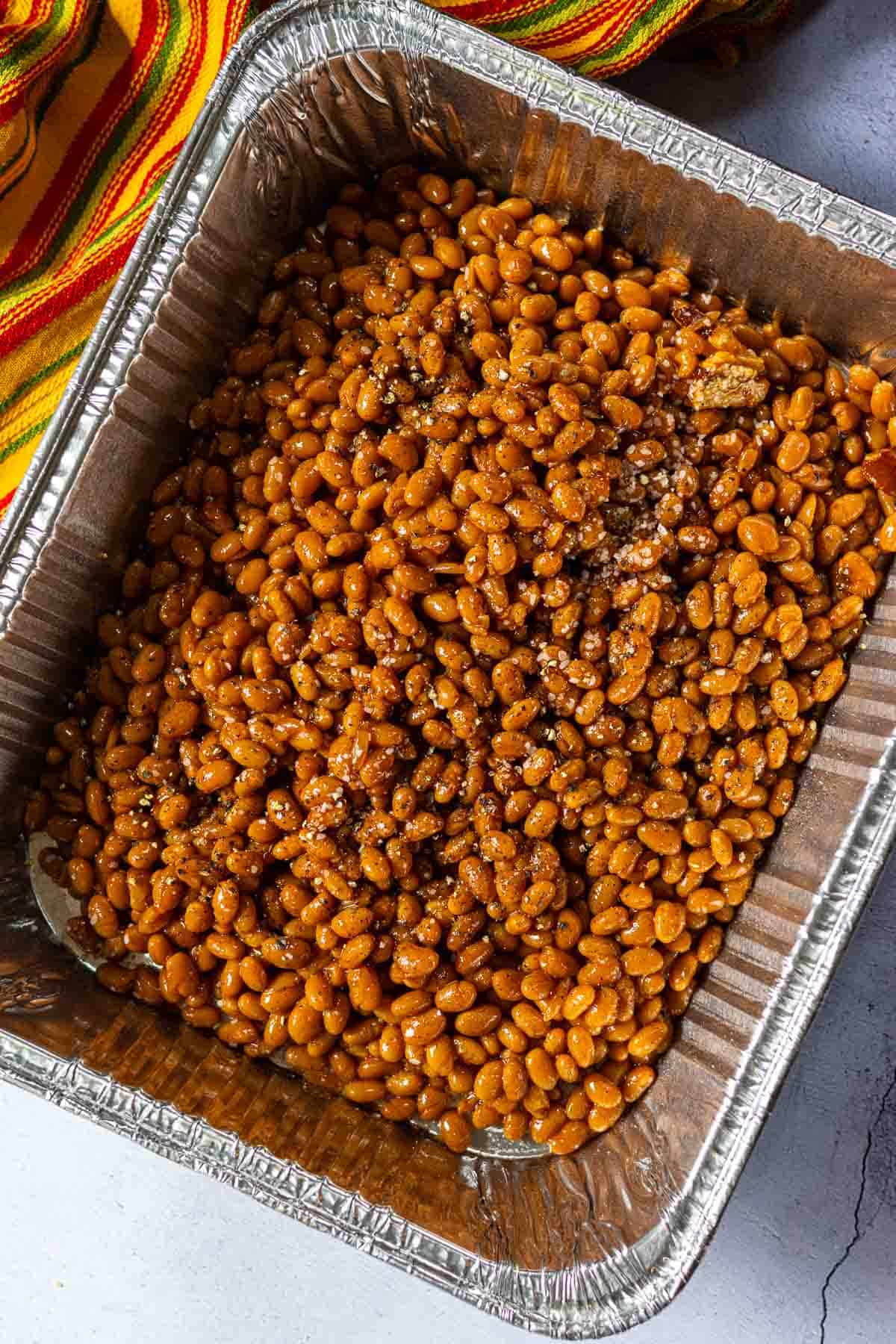BBQ baked beans in an aluminum casserole pan.