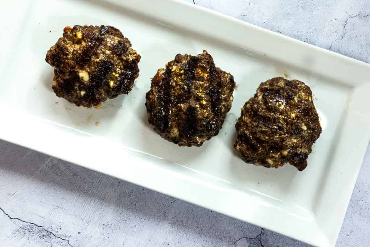 Grilled black and blue burger patties.