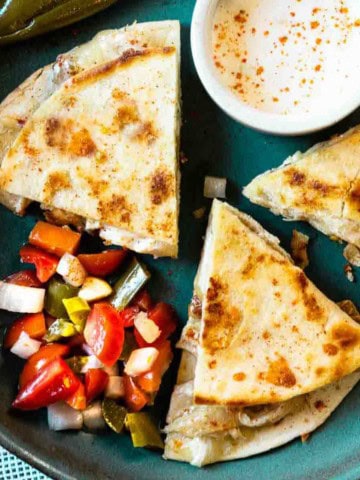 Chili's chicken bacon ranch quesadillas on a blue plate served with pico de gallo.