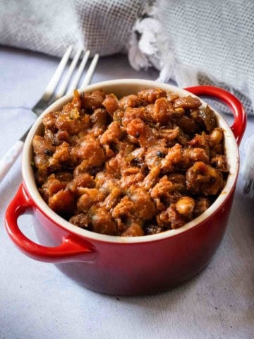 BBQ Baked beans on the grill served in a red ramekin.