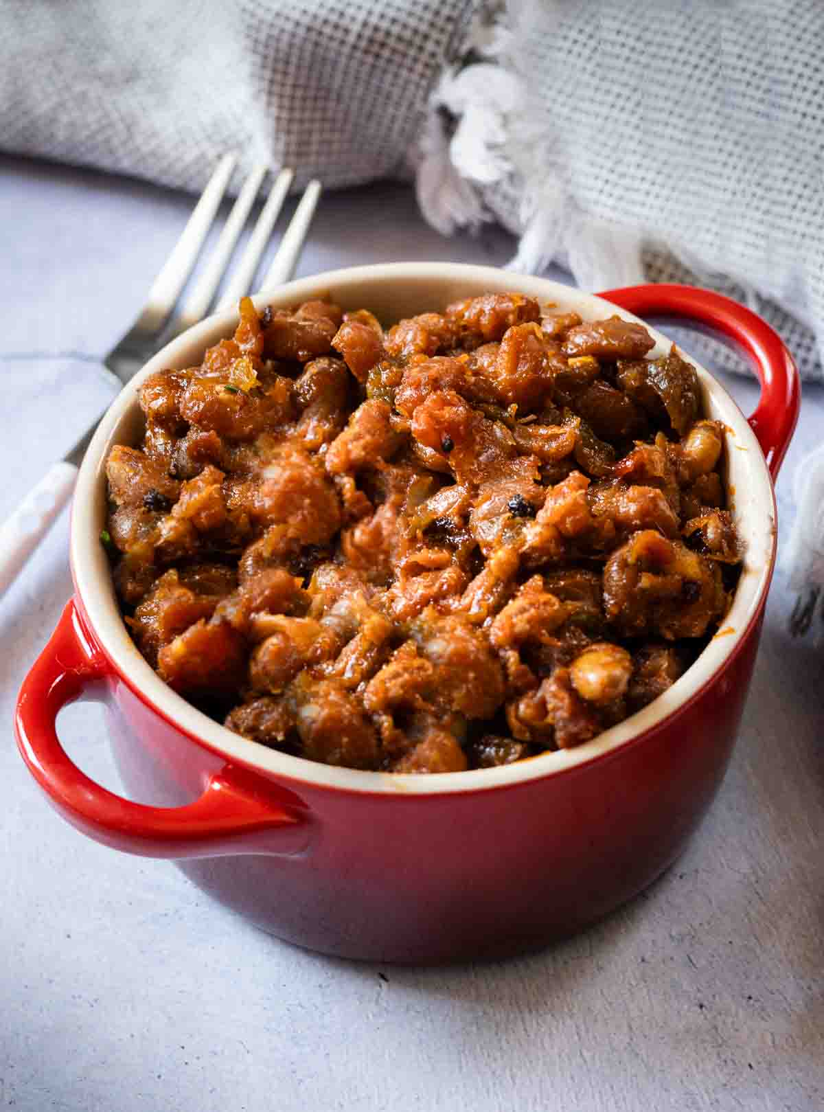 BBQ Baked beans on the grill served in a red ramekin.
