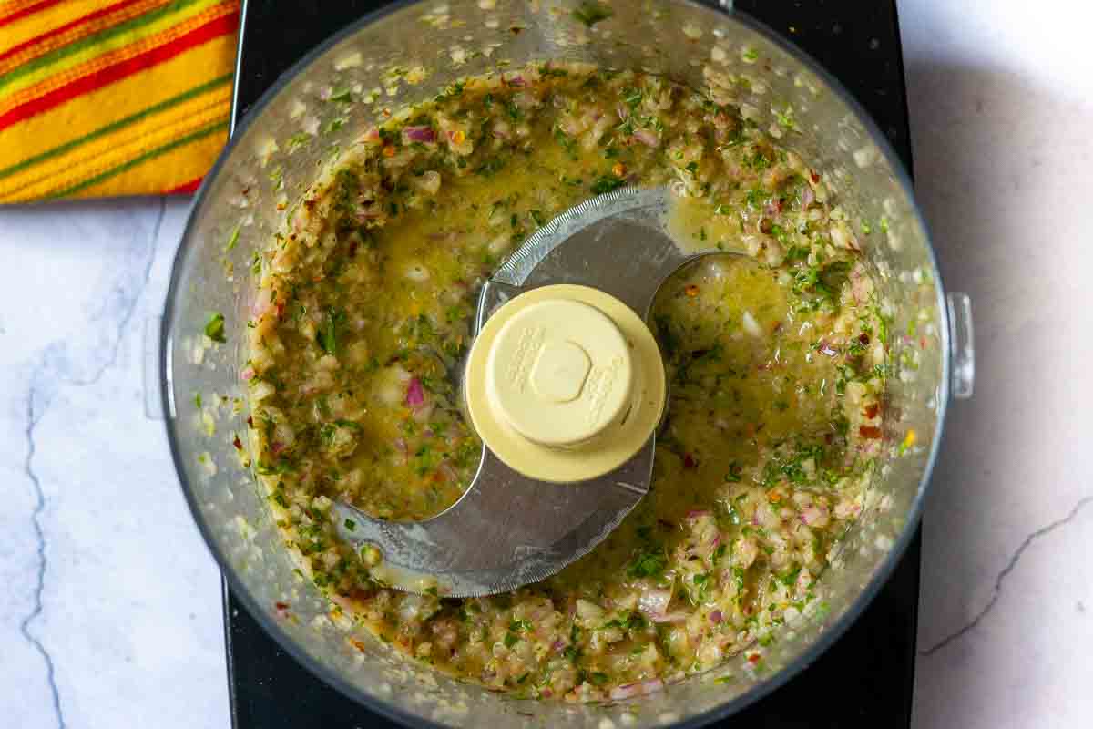 Pulsing chimichurri sauce in food processor to make chimichurri shrimp.
