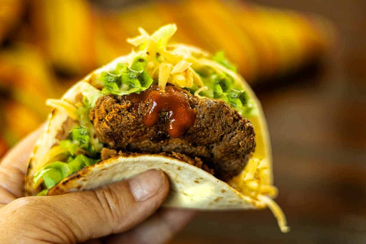 Eating a tortilla burger with your hands.
