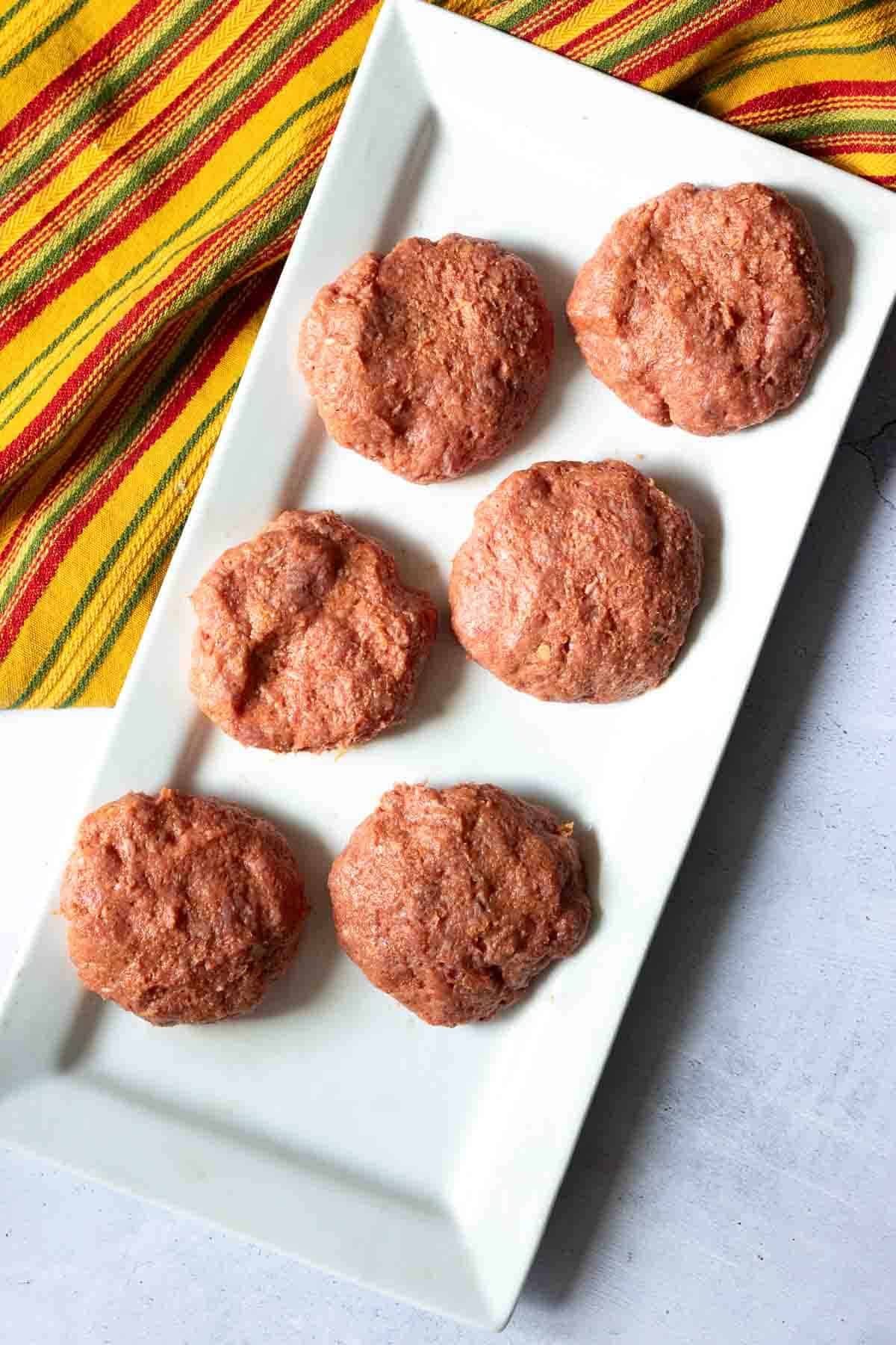 Making small burger patties to make tortilla burgers.