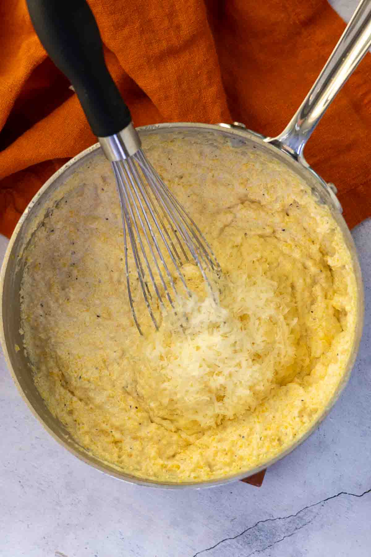 Making polenta with half and half and Parmesan cheese.