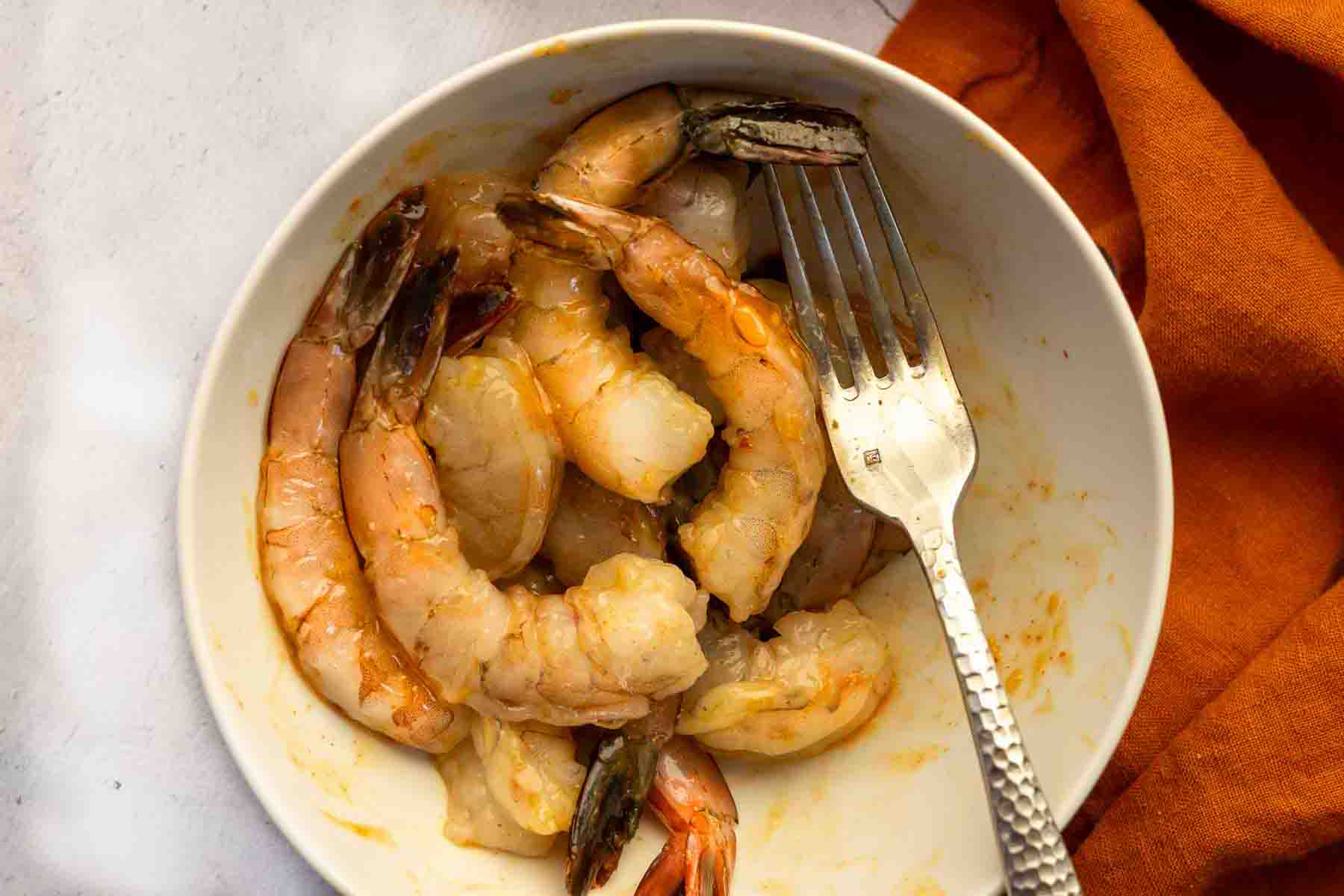 Coating shrimp with piri piri sauce.