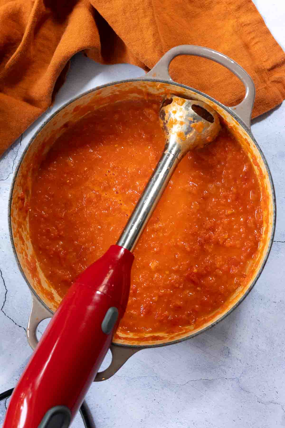 Using an immersion blender to thin sauce to make Shrimp and polenta.
