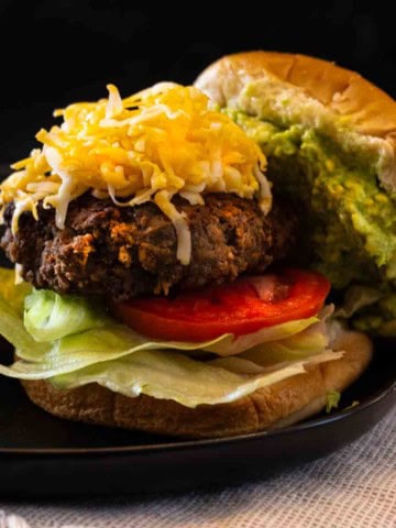 Taco Burger with shredded cheese and smashed avocado.