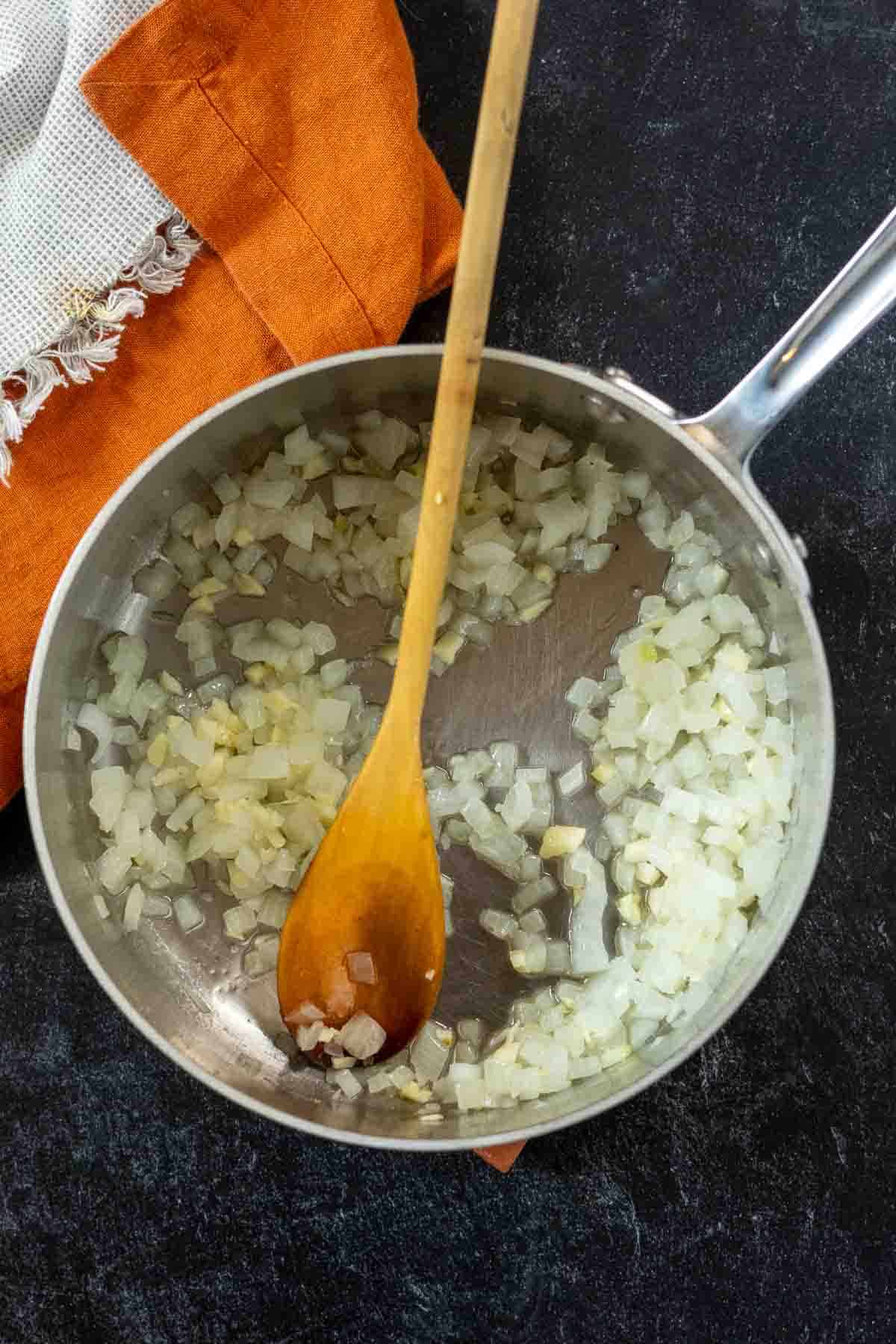 Cooking onions in a sauce pan to make red chile sauce from chile powder.