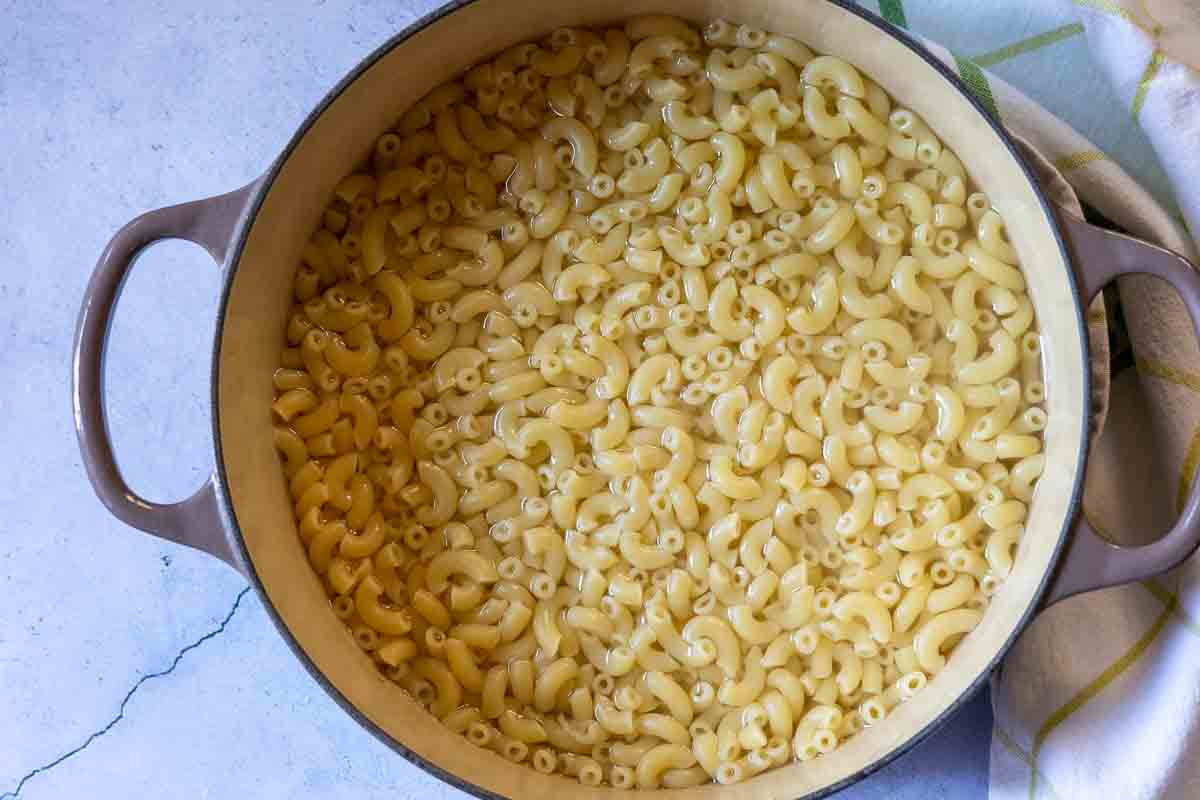 Step 1 to make white cheddar mac and cheese, cooking the macaroni noodles.