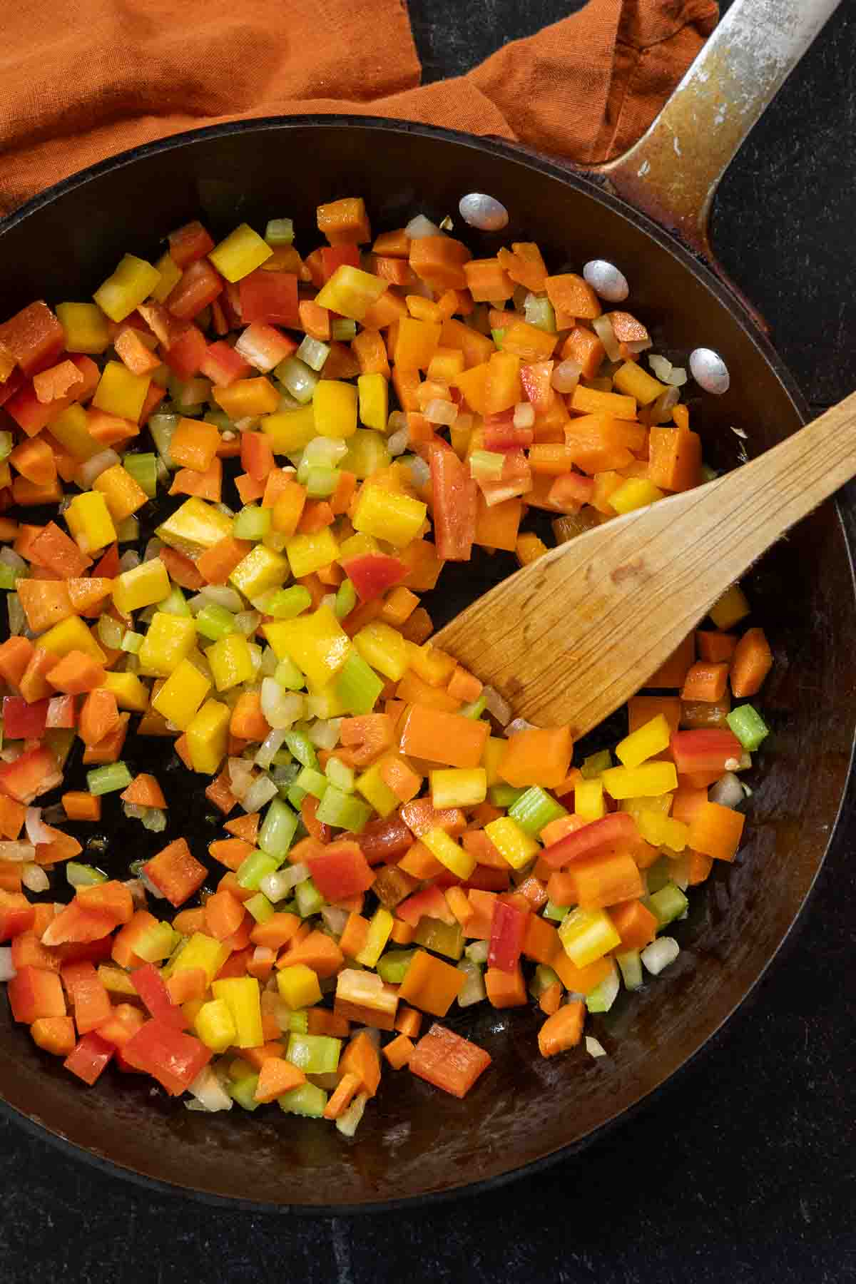 Adding bell peppers to mirepoix to make bean and beef soup.