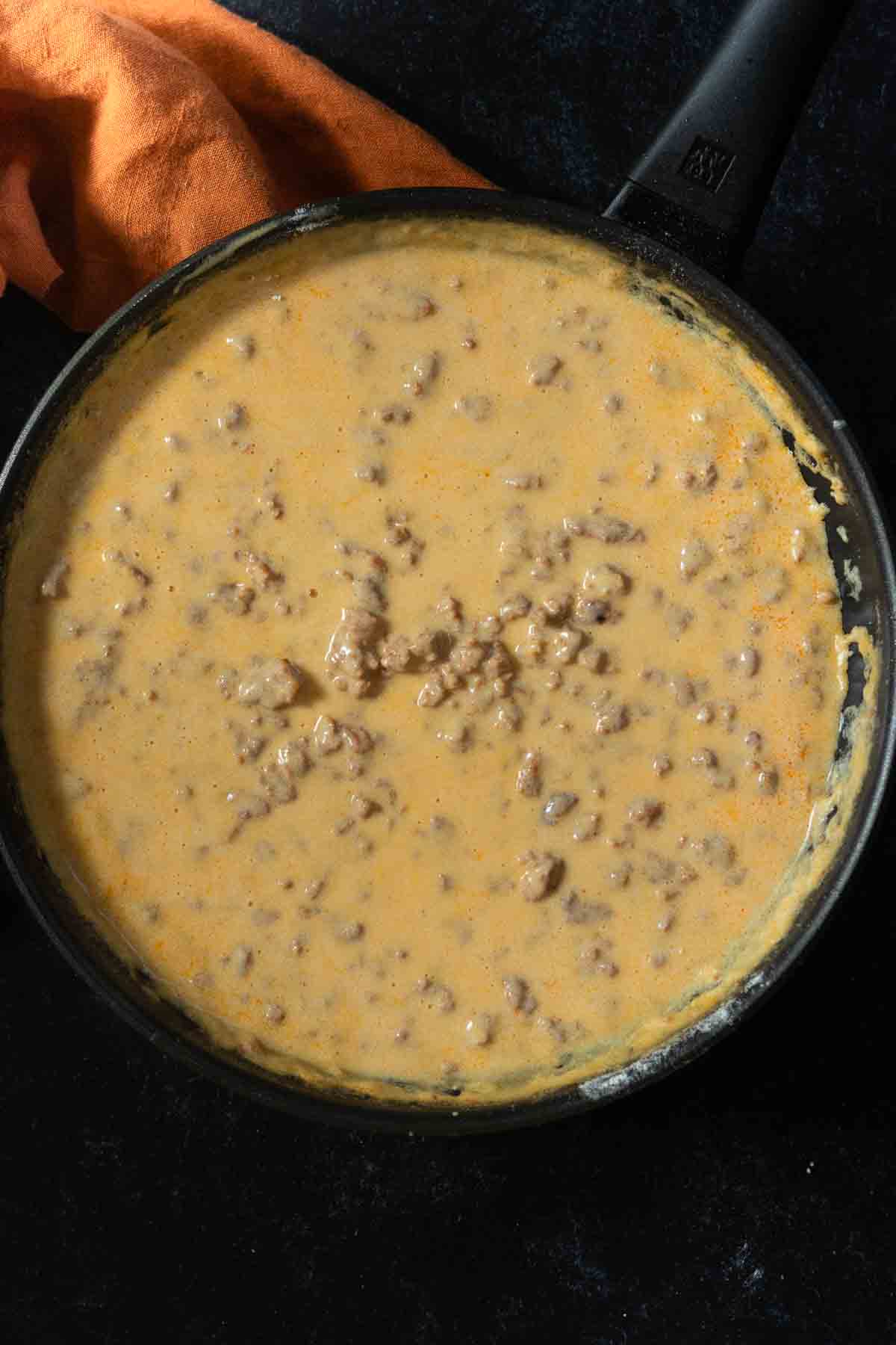 Making chorizo gravy in a skillet.