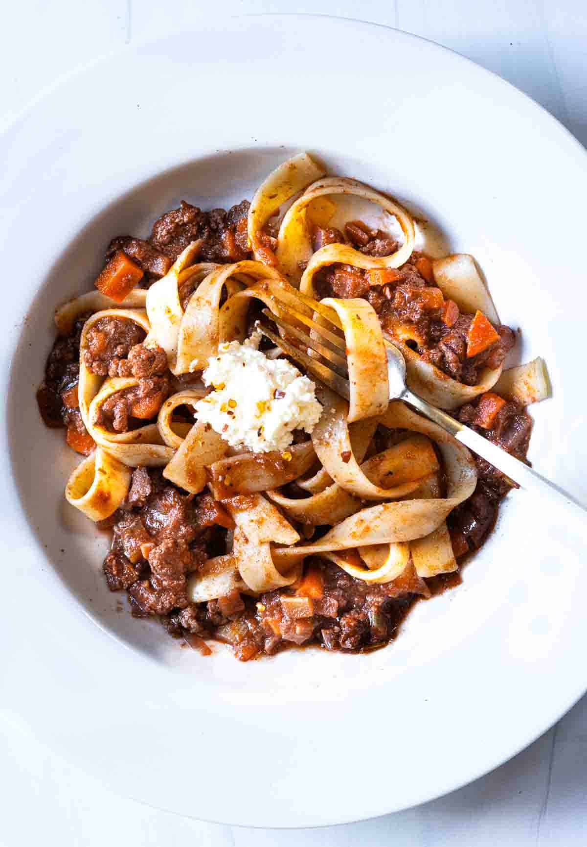 Lamb ragu with pappardelle pasta topped with ricotta cheese.
