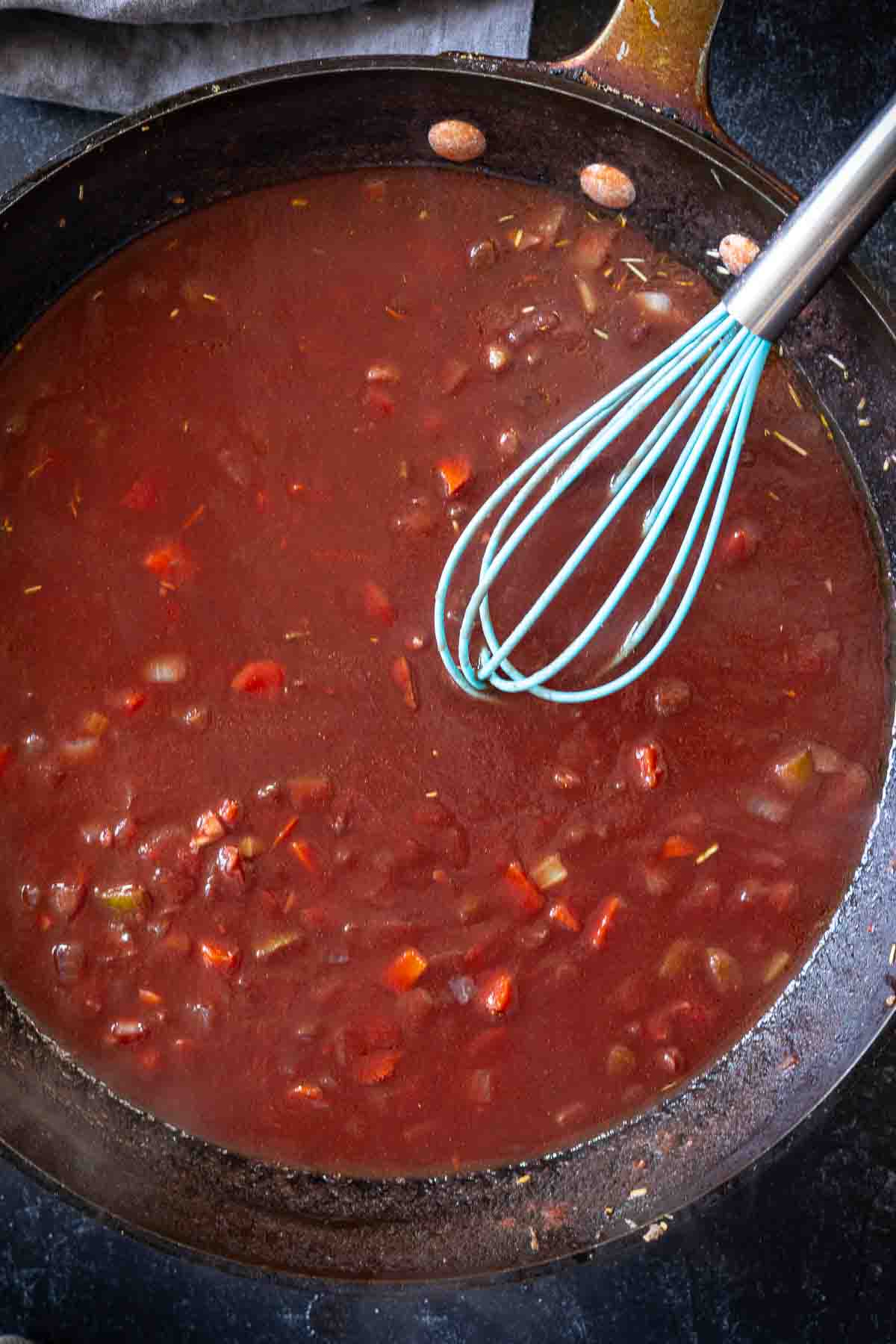 Making sauce in a skillet to make lamb ragu.