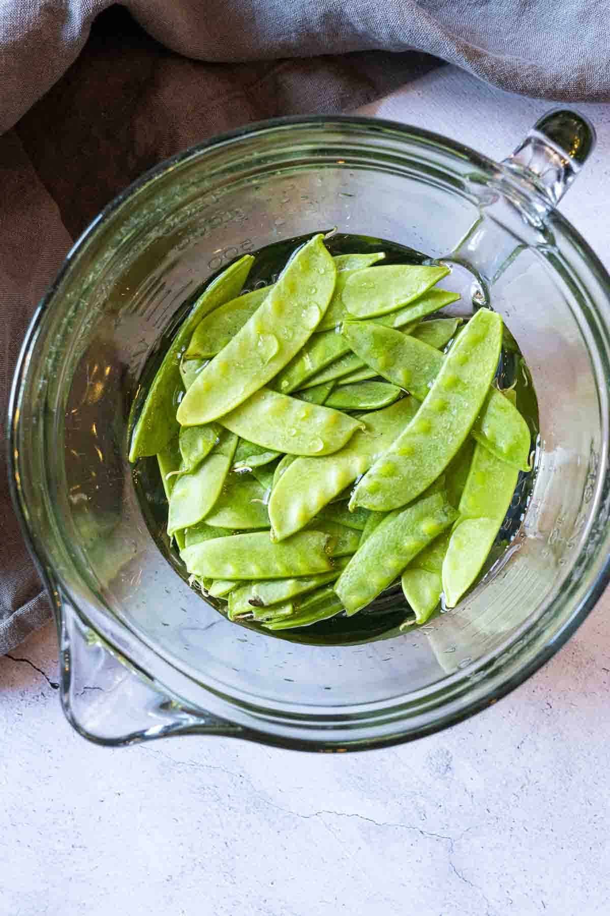 Blanching snow peas to make pan fried sea bass.