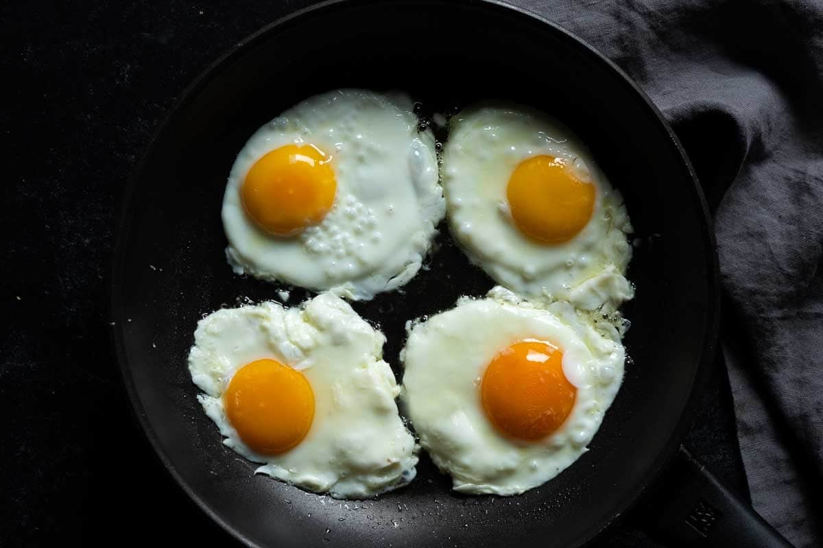 Cooking sunny side up eggs to make divorced eggs.