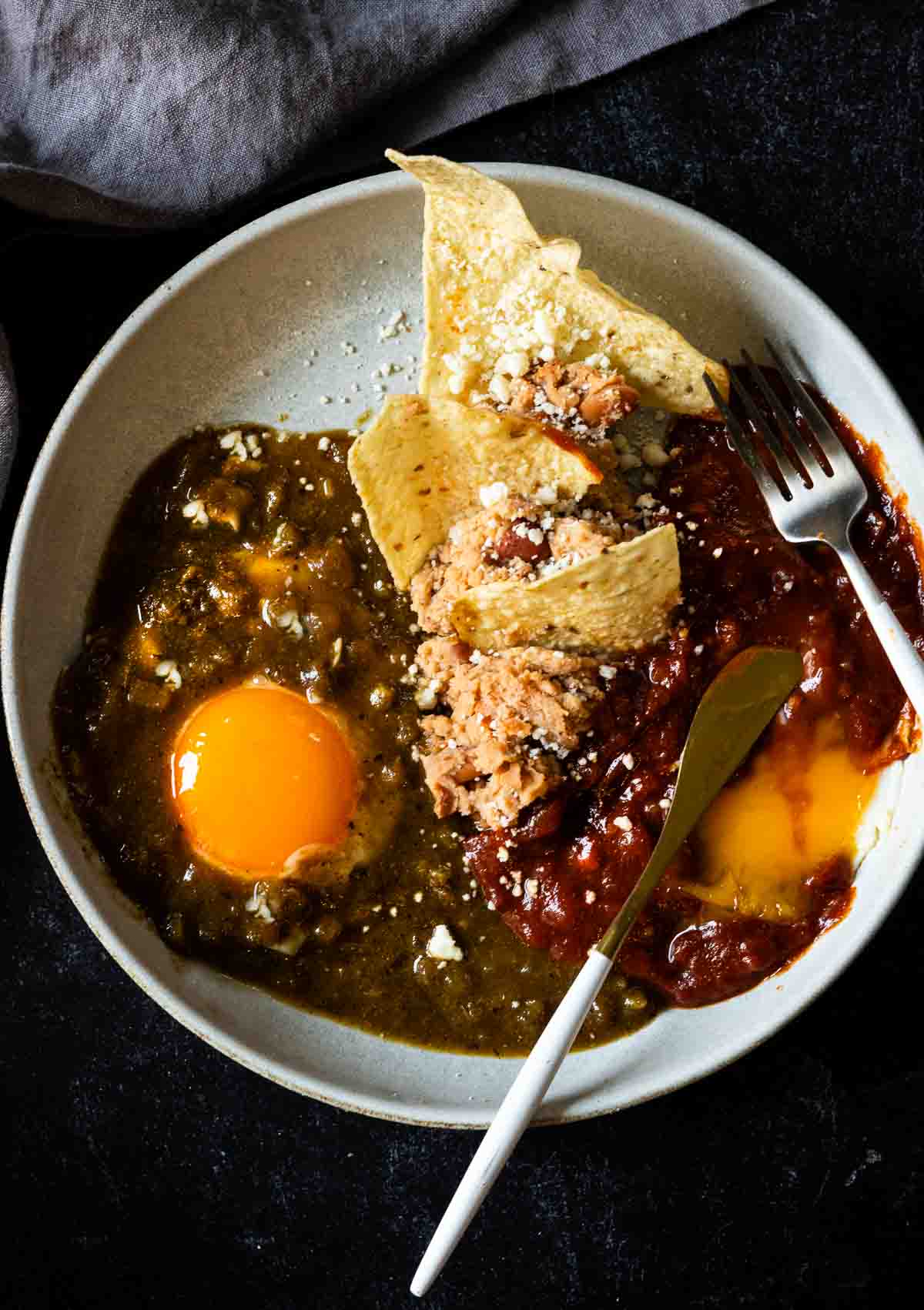 Divorced eggs served with two salsas. refried beans and tortilla chips.