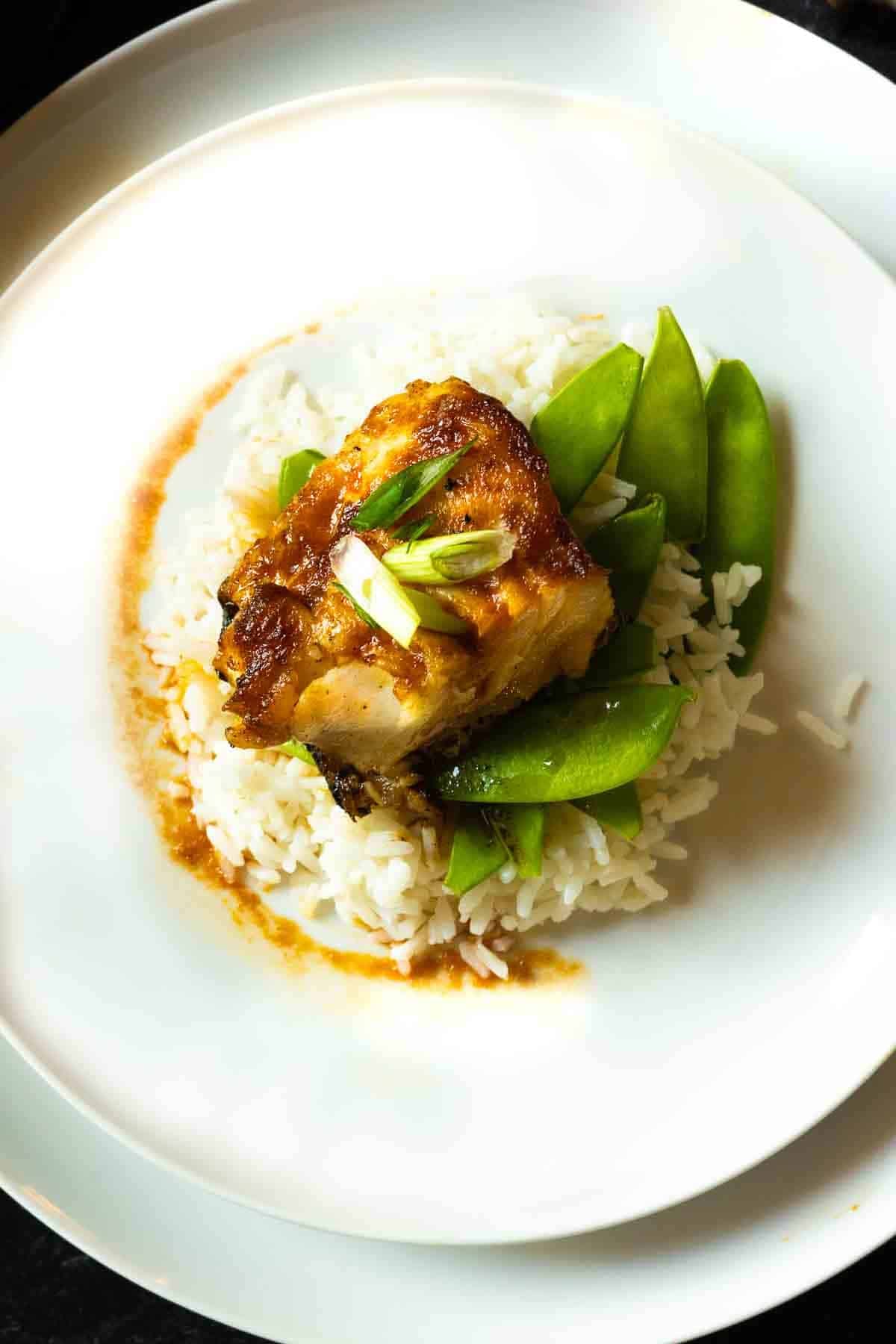 Pan fried Sea Bass served over cooked rice and snow peas.